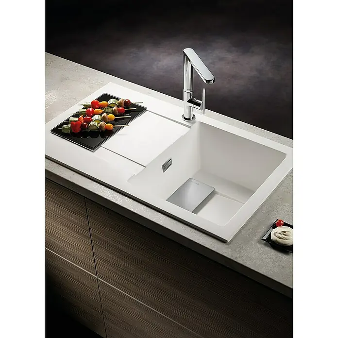 Pyramis Einbauspüle Kartesio - 79 x 50 cm, Carbon - Eine moderne Küchenspüle aus weißem Material mit einem eleganten Wasserhahn, dekoriert mit leckeren Spießen und einem cremigen Dessert.