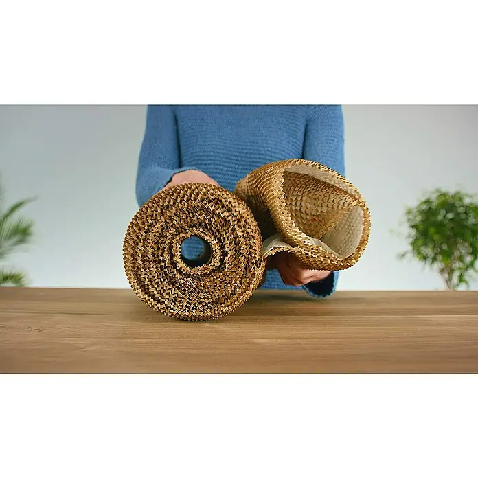 Ranpak Luftpolsterpapier NatureWrap - L x B: 10 m x 35 cm - Eine Person hält Rollen aus braunem Papierwabenmaterial, das als nachhaltige Verpackung dient.