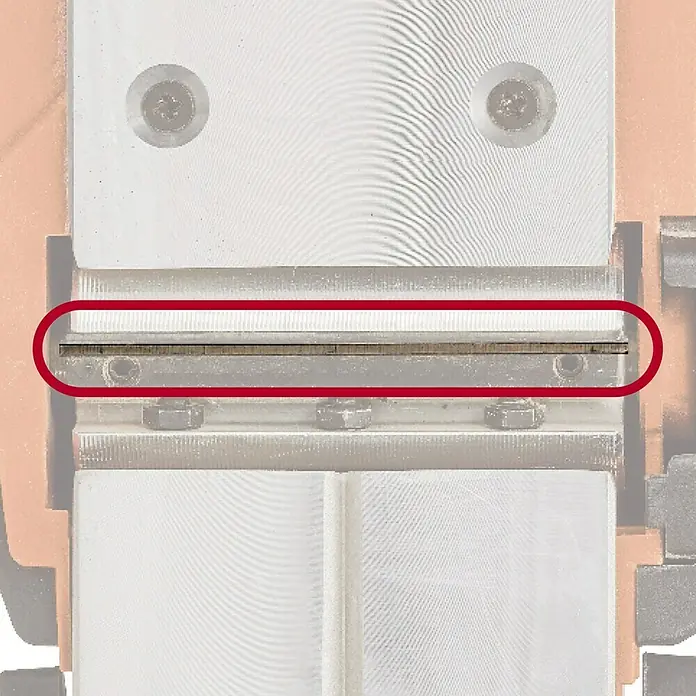 Einhell PXC 18V Cepillo de batería TE-PL 18/82 Li - Solo - 18 V, Sin batería, Número máx. de revoluciones en régimen de marcha en vacío: 15.000 r.p.m. - Primer plano de una máquina de trabajo de metal de precisión, destacando un componente esencial dentro de un círculo rojo.