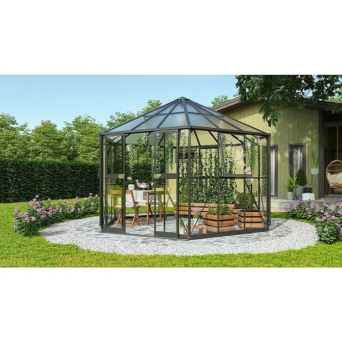 Vitavia Gewächshaus Pi 9000 - Außenmaß inkl. Dachüberstand (B x T): 336 x 383 cm, 3 mm, Schwarz - Ein elegantes sechseckiges Gewächshaus mit Pflanzen und einem Tisch auf einem Kiesweg im Garten.