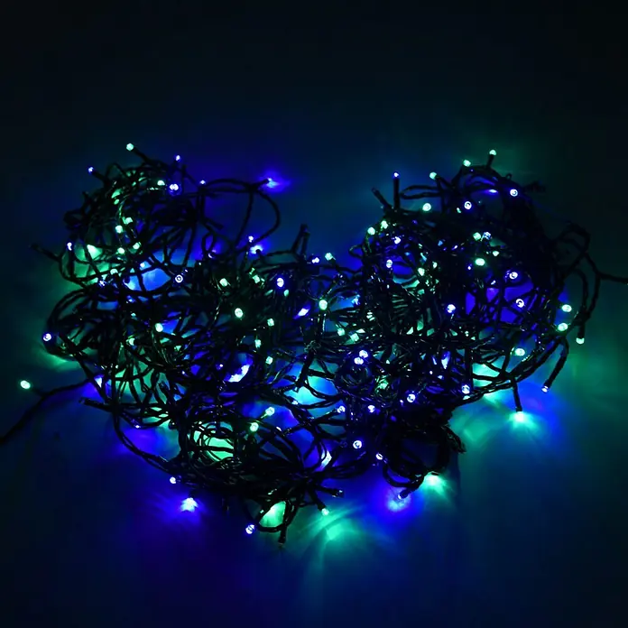 Muvit iO Guirnalda luminosa LED WiFi RGB+CCT - 20 m, RGB, Para interior - Disposición en forma de corazón de luces azules y verdes sobre un fondo oscuro. Iluminación decorativa para ocasiones festivas.