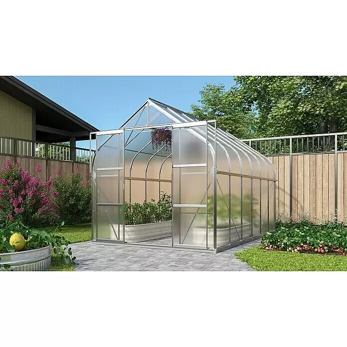 Vitavia Gewächshaus Dione 9900 - 383 cm x 263,5 mm x 254,5 mm, Wandstärke: 4 mm, Aluminium - Großes, silbergerahmtes Gewächshaus mit lichtdurchlässigen Paneelen, gewölbtem Dach und Schiebetüren im Garten, mit Pflanzen darin.