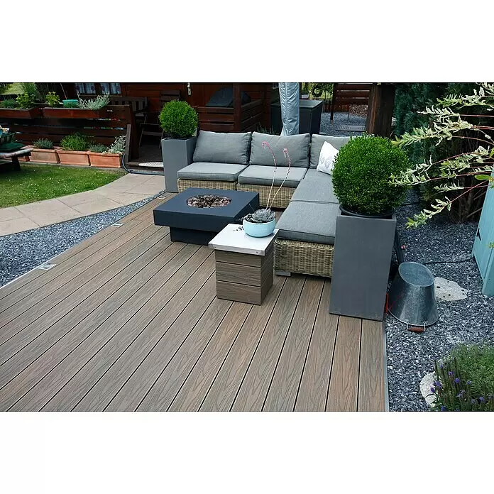 Elephant Terrassenbau-Set WPC strongWood - Teak/Grau, Deckfläche pro Paket: 12 m² - Braun-graue Verbundstoff-Terrassendielen bilden eine moderne Außenterrasse mit Lounge-Set und Feuerstelle im Garten.