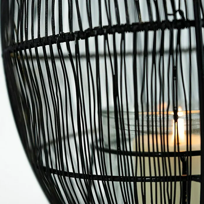 WindlichtØ x H: 19 x 25 cm, Schwarz - Nahaufnahme einer Laterne mit Kerze im Inneren, die ein warmes Licht durch das schwarze Geflecht wirft.