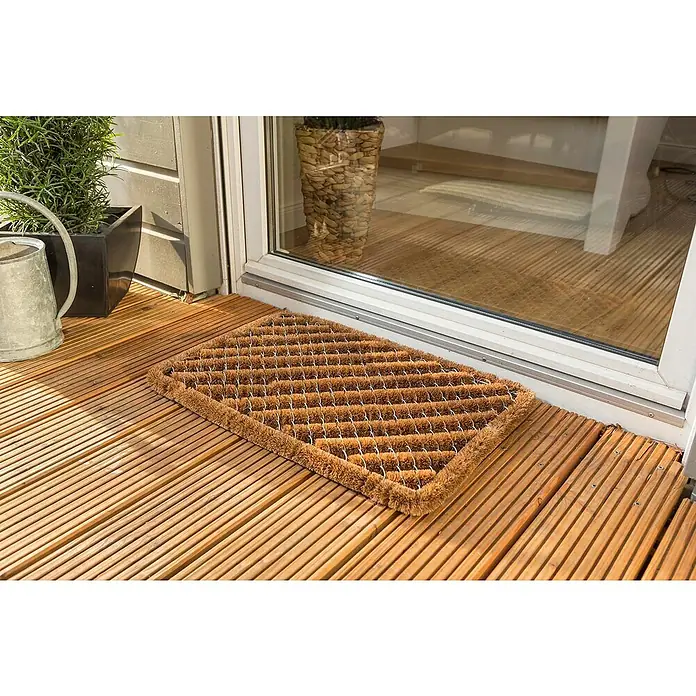 Astra Coco Fußmatte Brush - 40 x 60 cm, Kokos, Standard - Detailaufnahme einer Fußmatte aus Kokosfasern vor einer Terrassentür, die durch ihr rustikales Design besticht.