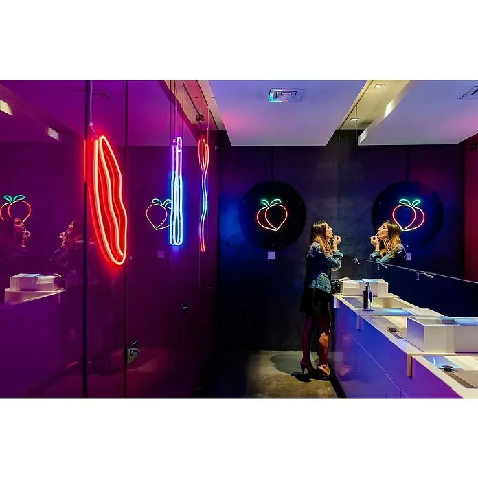 Twinkly Tira de luces LED Flex - Largo: 2 m, Color de luz: RGB, 15 W - Reflejo de mujer en baño elegante con neones de melocotón, creando un ambiente moderno y divertido.