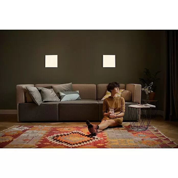 Ledvance SUN@Home LED-Panel Planon Frameless - 20 W, L x B x H: 30 x 30 x 6,1 cm, Weiß, Kaltweiß - Zwei quadratische weiße Wandleuchten beleuchten eine dunkelgrüne Wand über einem Sofa im Wohnzimmer.