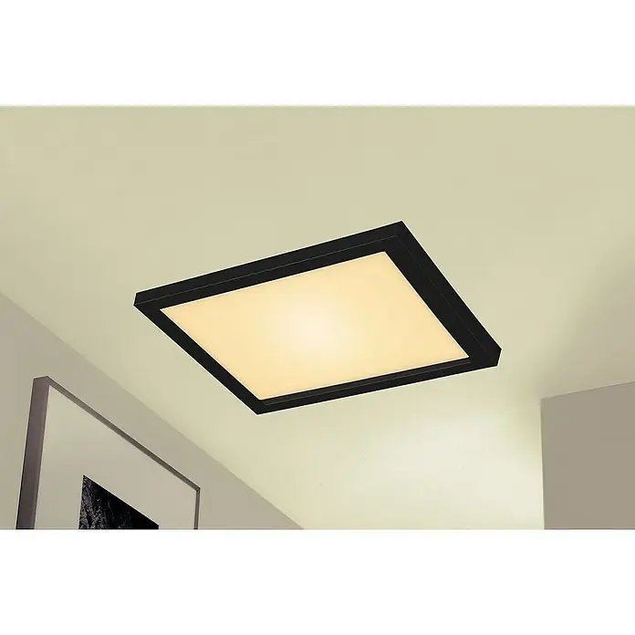 Briloner LED-Panel - 18 W, L x B x H: 29,5 x 29,5 x 8 cm, Schwarz, Warmweiß - Nahaufnahme einer quadratischen Deckenleuchte mit schwarzem Rahmen, die ein warmes, diffuses Licht in einem modernen Raum ausstrahlt.