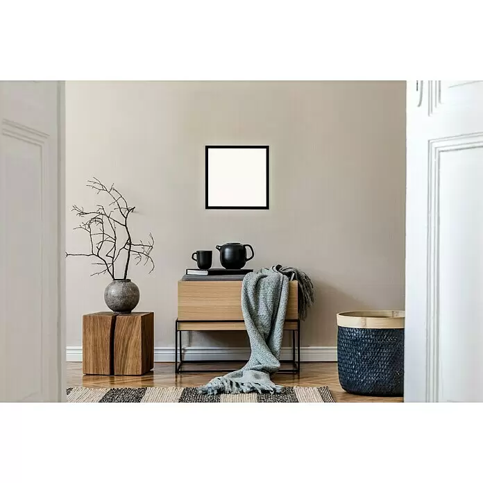Briloner LED-Panel - 24 W, L x B x H: 44,5 x 44,5 x 8 cm, Schwarz, Warmweiß - Leerer schwarzer quadratischer Bilderrahmen an einer beigefarbenen Wand, ausgestellt in einem stilvollen Raum mit modernen Möbeln und Dekoration.