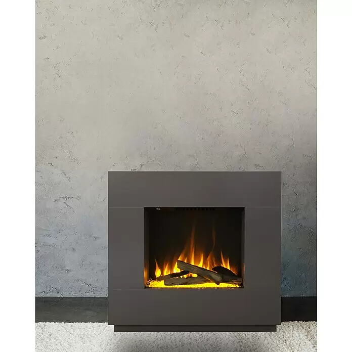 Voltomat HEATING Elektrischer Kamin Kalmar - Grau, 26 x 80 x 76 cm - Dunkelgrauer Elektrokamin mit leuchtenden orangefarbenen Flammen und Holzscheiten, auf dunklem Boden vor einer grauen Wand und weißem Teppich.