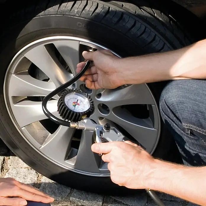 Einhell Reifenfüllmesser Profi - Betriebsdruck: 8 bar - Ein Autofahrer prüft den Reifendruck mit einem Reifendruckprüfer. Die Messung wird auf dem Manometer angezeigt.
