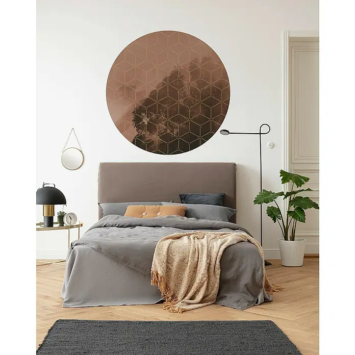 Komar Dots Fototapete rund New Morning - 128 cm, Selbstklebend - Schlafzimmer mit einem bequemen Bett, einer runden Wandkunst, einem Nachttisch mit Lampe und einer Zimmerpflanze.