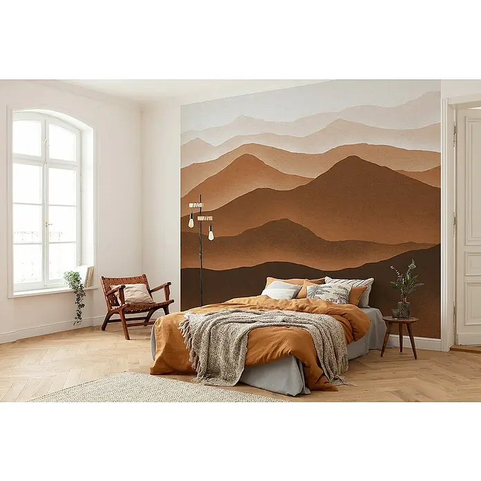 Komar Fototapete Macchiato Mountains - B x H: 300 x 250 cm, Vlies - Einladendes Schlafzimmer mit Wandgemälde, Bett mit orangefarbener Bettwäsche und einer Tagesdecke, das für Komfort und Stil sorgt.