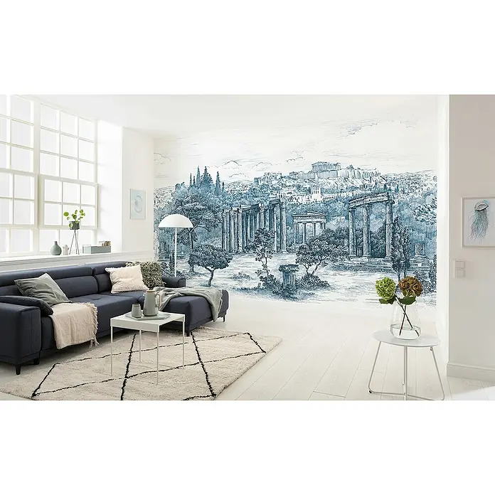 Komar Fototapete Ruins - B x H: 400 x 250 cm, Vlies - Wohnzimmer mit blauem Sofa, Teppich und Wandbild mit antiken Ruinen, ergänzt durch moderne Beistelltische und dekorative Elemente.