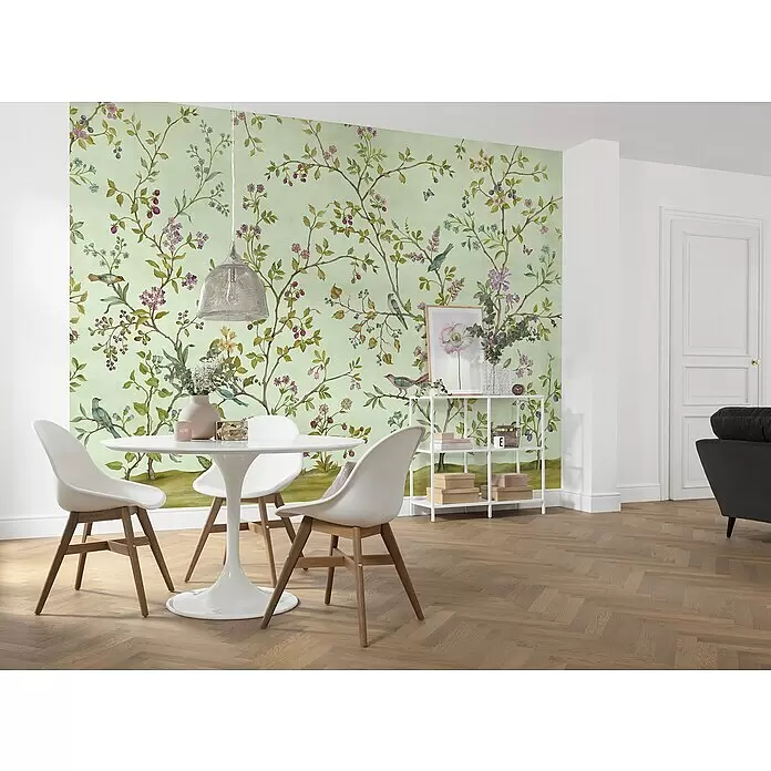 Komar Fototapete Oiseaux du Paradis - B x H: 350 x 250 cm, Vlies - Hellgrüne Tapete mit Naturmuster aus Ästen, Beeren, Blumen und Vögeln an einer Esszimmerwand.