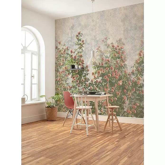 Komar Fototapete Wall Roses - B x H: 300 x 250 cm, Vlies - Florale Tapete mit kletternden Rosenbüschen in einem Esszimmer mit hellem Holztisch.