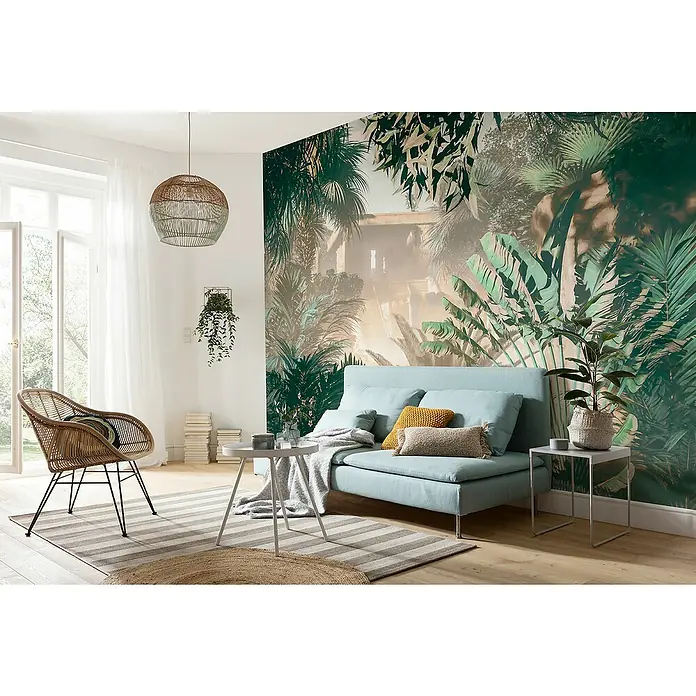 Komar Fototapete Manoa - B x H: 350 x 250 cm, Vlies - Wohnzimmer mit hellblauem Sofa, Rattansessel und Dschungeltapete. Die dekorative Hängeleuchte und Zimmerpflanzen sorgen für eine gemütliche Atmosphäre.