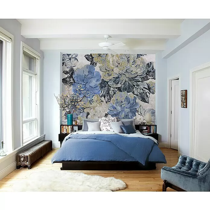 Komar Fototapete Chérie - B x H: 300 x 250 cm, Vlies - Ein Bett mit tiefblauem Bettbezug und mehrschichtigen Kissen in Grau- und Blautönen, in einem Schlafzimmer mit floraler Akzentwand.