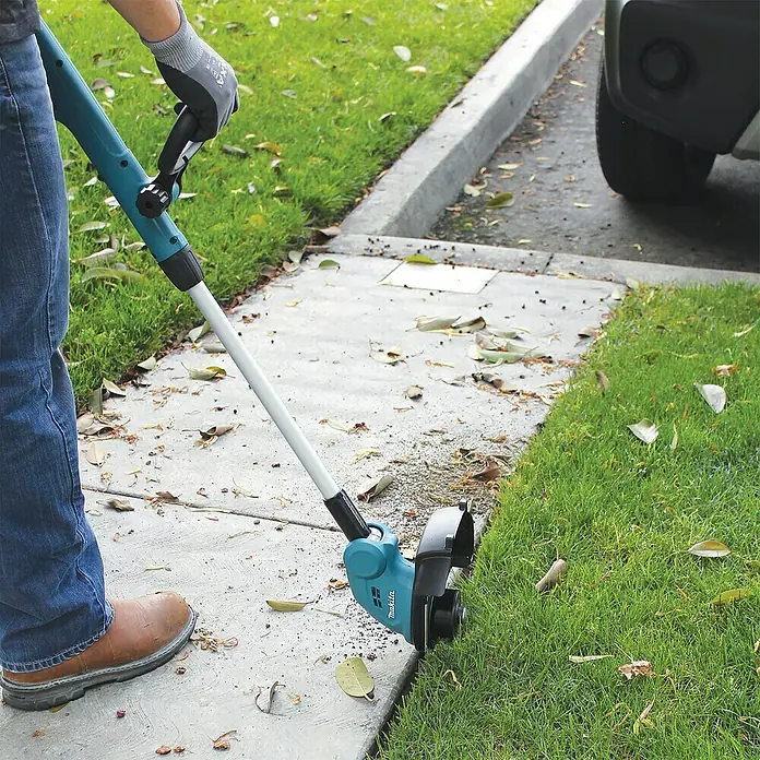 Makita LXT 18V Akku-Rasentrimmer DUR181Z - 18 V, Li-Ionen, Ohne Akku, Schnittbreite Faden: 260 mm - Eine Person, die einen Makita Rasentrimmer an einer Rasenkante benutzt.