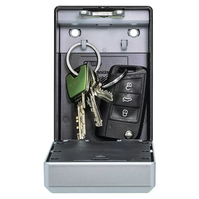 Abus Schlüsselbox Key Garage 787 Smart Bluetooth - Geeignet für: Bis zu 20 Schlüssel, L x B x H: 63 x 82,55 x 120 mm, Ohne Bügel - Ein offener silberner und schwarzer Schlüsselsafe enthält einen Hausschlüsselsatz mit grünem Anhänger und eine schwarze Autoschlüsselfernbedienung.