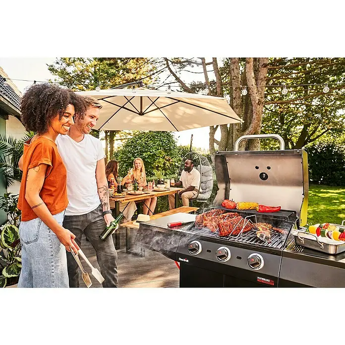 Char-Broil Gasgrill Performance Core B3 - Grillfläche (B x T): 54,3 x 43,5 cm, 7,91 kW, Anzahl Brenner: 3 - Grillparty im Garten: Ein Char-Broil Grill mit Steaks, Gemüse und Spießen, umgeben von Freunden und Familie unter einer Lichterkette.