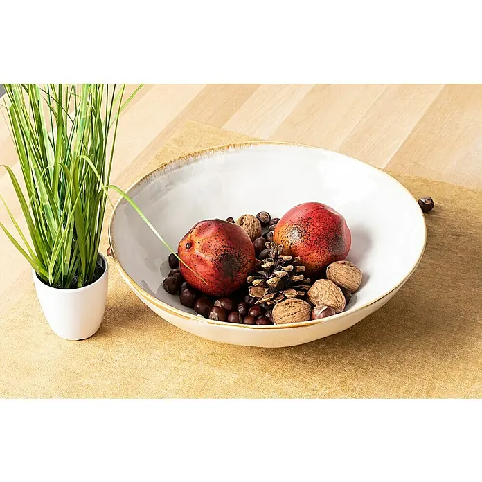 Schale Tabo - Ø x H: 30,5 x 9 cm, Weiß - Dekorative Schale mit Nüssen, Kastanien und Kunstfrüchten auf einem Tisch, neben einem kleinen Topf mit künstlichem Gras.