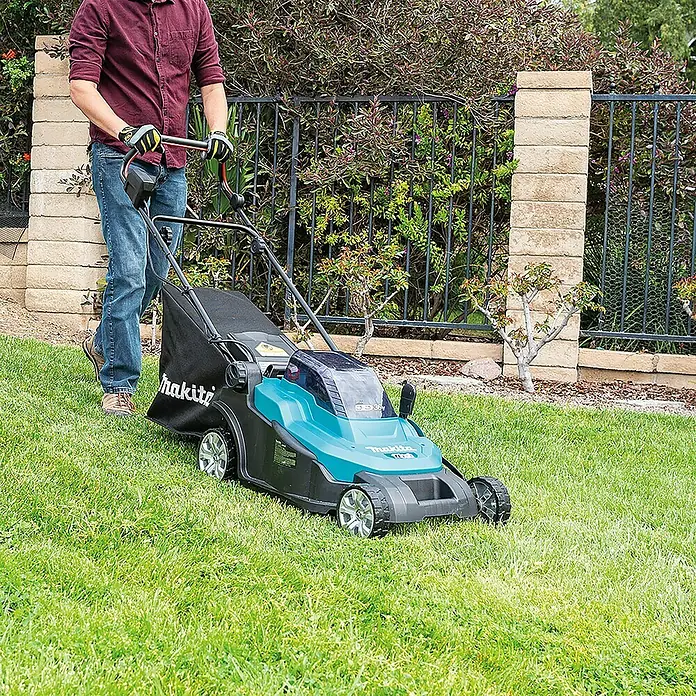 Makita LXT 18V Akku-Rasenmäher DLM432Z - 36 V, Ohne Akku, Schnittbreite: 43 cm - Rasenmäher der Marke Makita im Einsatz. Der Akku-Rasenmäher mit Fangkorb wird von einer Person bedient, um den Rasen zu pflegen.