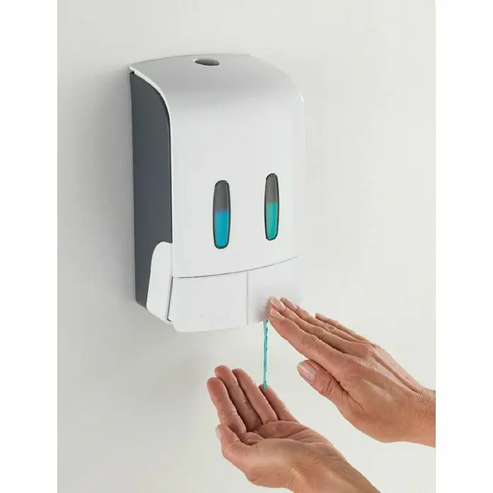 Wenko Dispensador de jabón Tartas - Plástico, Blanco, Capacidad del depósito: 960 ml - Dispensador de jabón líquido con contenido azul. Las manos de una persona están debajo del dispensador de jabón para recibir jabón.