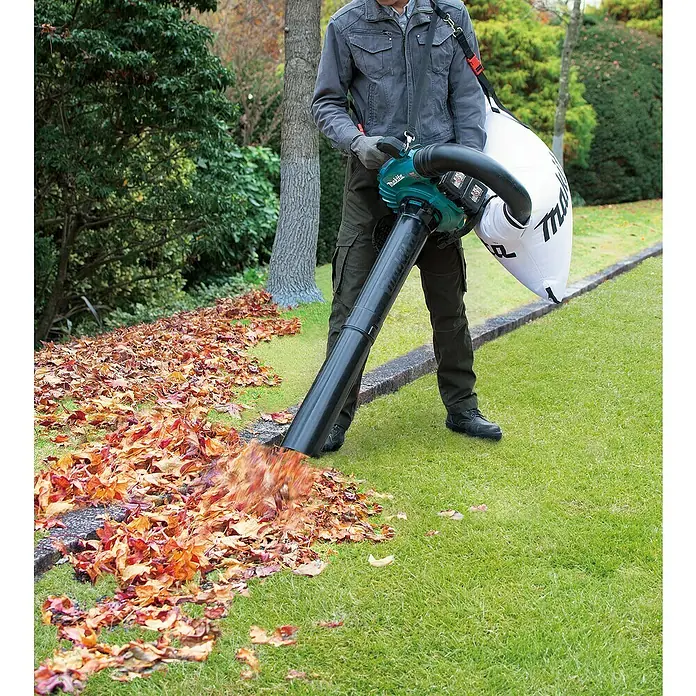 Makita LXT 18V Akku-Laubbläser DUB363ZV - 18 V, Li-Ionen, Ohne Akku, Blasleistung: 13,4 m³/min - Ein Mann benutzt einen Makita Laubbläser, um Blätter von einem Rasen zu entfernen. Das Gerät ist mit einem großen Fangsack ausgestattet.