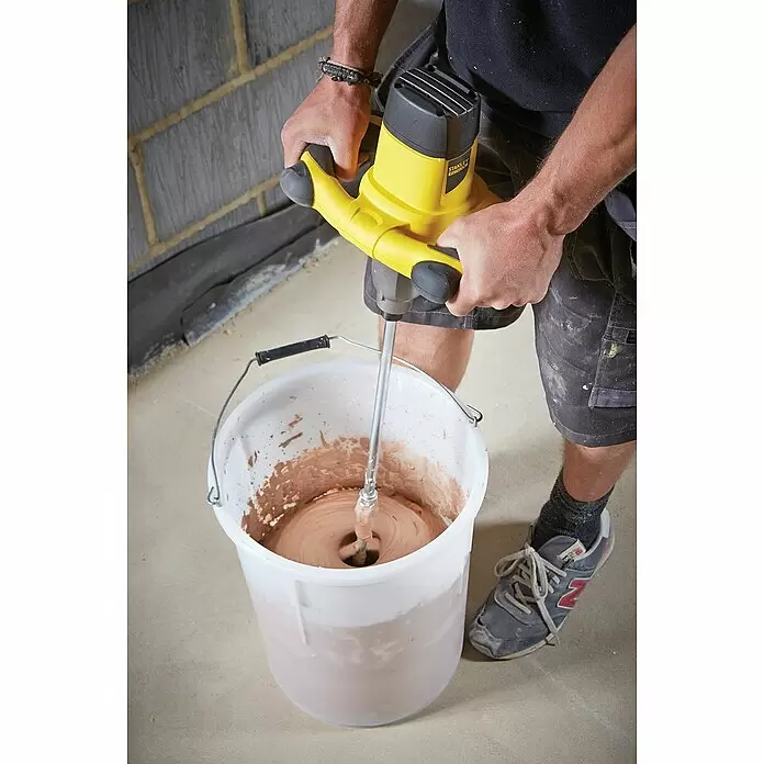Stanley FatMax Farb- & Mörtelmischer FME190-QS - 1.600 W, Durchmesser Rührer: 150 mm, Mischvolumen: 120 l - Person mischt braunes Material in weißem Eimer mit gelb-schwarzem Rührgerät.