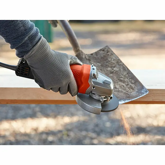 Black+Decker Elektro-Winkelschleifer BEG110-QS - 750 W, 115 mm - Nahaufnahme eines Winkelschleifers mit Schutzhandschuhen beim Bearbeiten einer Schaufel, wobei Funken fliegen.
