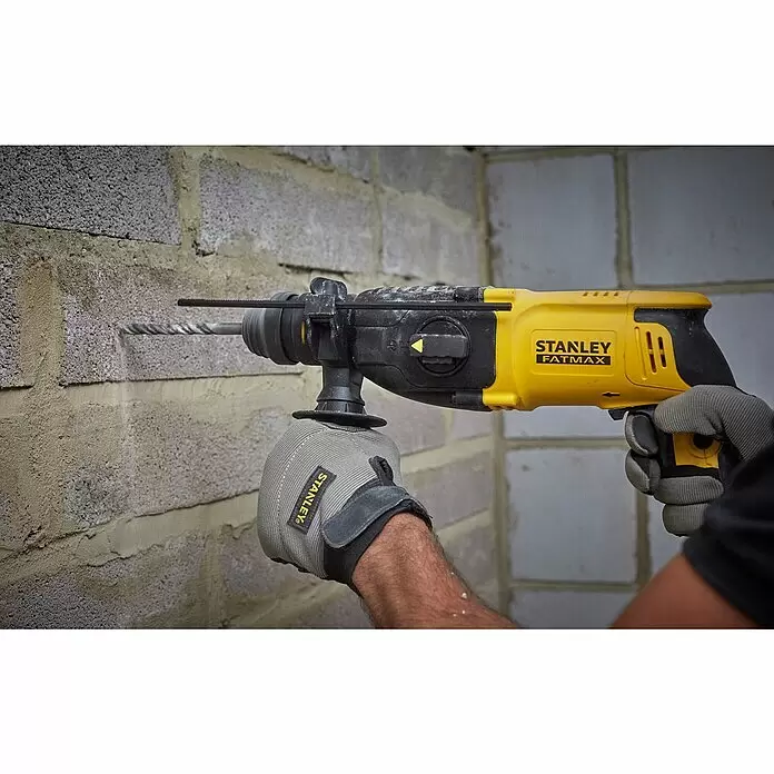 Stanley FatMax Kombihammer SFMEH210K-QS - 800 W, 2,4 J, SDS-Plus-Aufnahme - Gelber und schwarzer Stanley Fatmax Bohrhammer, von einer behandschuhten Hand in eine graue Ziegelwand bohrend.