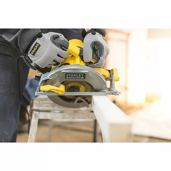Stanley FatMax Handkreissäge FME301-QS - 1.650 W, Durchmesser Sägeblatt: 190 mm, Schnitttiefe bei 90 °: 66 mm - Eine Person in grauen Stanley-Handschuhen bedient eine gelb-graue Stanley Fatmax Kreissäge, die einen Holzbalken schneidet.