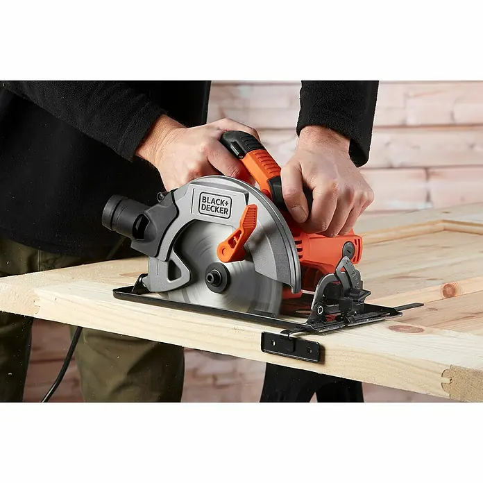 Black+Decker Handkreissäge CS1550-QS - 1.500 W, Durchmesser Sägeblatt: 190 mm, Schnitttiefe bei 90 °: 66 mm - Nahaufnahme einer Black+Decker Kreissäge beim Schneiden eines Holzbretts.