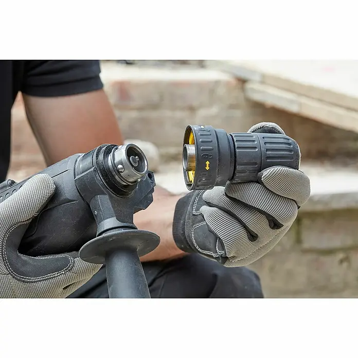 Stanley FatMax Kombihammer SFMEH210K-QS - 800 W, 2,4 J, SDS-Plus-Aufnahme - Eine Nahaufnahme eines Mannes, der mit behandschuhten Händen einen Bohrhammer und einen Bohreraufsatz hält, um diese zusammenzusetzen.