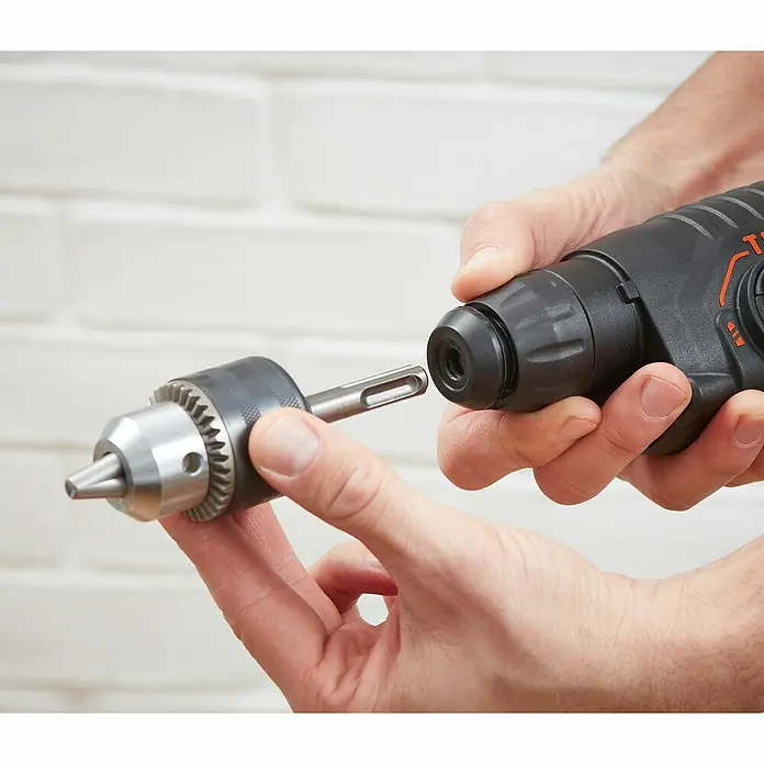 Black+Decker Kombihammer BEHS01K-QS - 650 W, 1,4 J, SDS-Plus-Aufnahme - Ein Bohrer mit austauschbarem Bohrkopf wird gezeigt. Der Bohrer ist schwarz und orange.