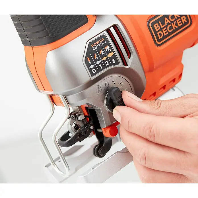 Black+Decker Elektro-Stichsäge BES610K-QS - 1.000 /min - 3.100 /min, 90 mm - Nahaufnahme einer Black+Decker Stichsäge, die von einer Hand bedient wird.