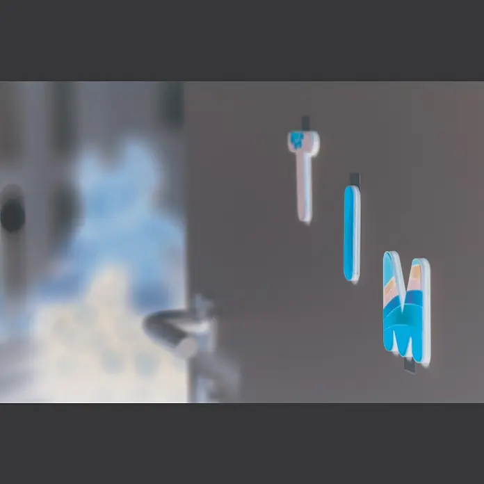 Tesa Powerstrips Selbstklebestrip Small - 14 Stk. - Nahaufnahme von bunten Buchstabenmagneten, die ein stilvolles und verspieltes dekoratives Element bilden.