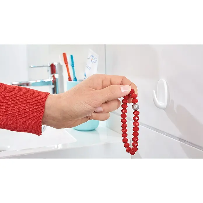 Tesa Powerstrips Selbstklebehaken - Oval, Größe: S, Weiß, 3 Stk. - Eine rote Perlenkette wird in einem Badezimmer mit einem weißen Haken an der Wand präsentiert, ideal für die Organisation.