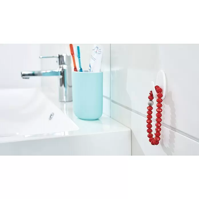 Tesa Powerstrips Selbstklebehaken - Oval, Größe: S, Weiß, 3 Stk. - Weißer Haken im Badezimmer, hält rote Perlenarmbänder. Er ist über einem Waschbecken befestigt.