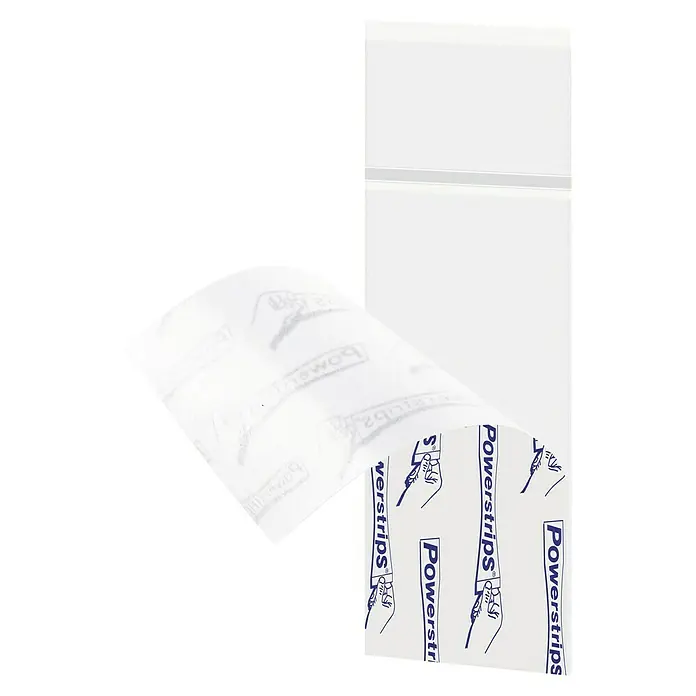Tesa Powerstrips Selbstklebestrip Transparent Large - 8 Stk. - Eine Nahaufnahme von Powerstrips, die zum Aufhängen von Objekten verwendet werden, mit einem Hintergrund eines weißen Schranks.