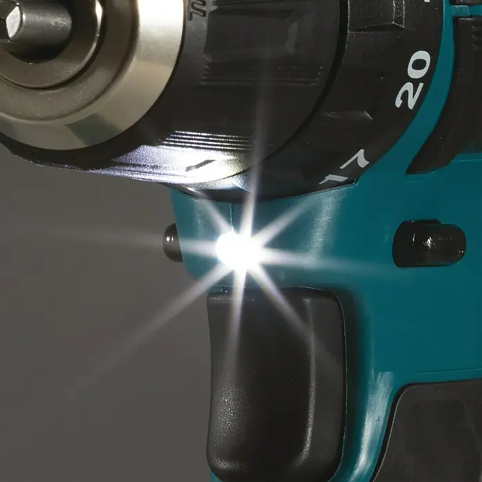Makita CXT 12V max. Akku-Schlagbohrschrauber HP333DSAX1 - 12 V, 2 Akkus, 2 Ah, 30 Nm, 2 Akkus + Koffer inkl. Zubehör - Nahaufnahme eines Akkuschraubers mit eingeschaltetem LED-Licht, das den Arbeitsbereich ausleuchtet.