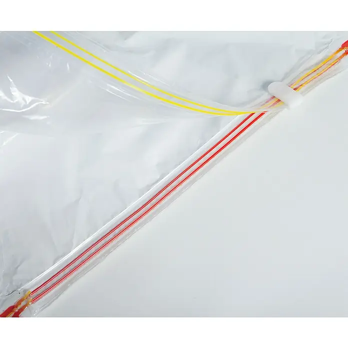 Set de bolsas de vacío HousyBags™ - 12 ud., Transparente - Primer plano de una bolsa de plástico transparente con cierres de cremallera amarillos y rojos, destacando los detalles del cierre.