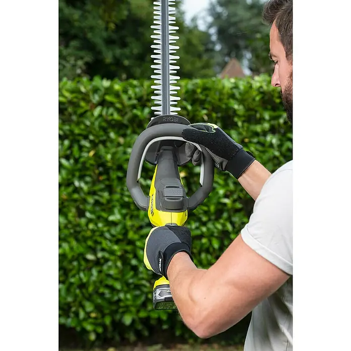 Ryobi ONE+ Akku-Heckenschere RY18HT55A-0 - 18 V, Li-Ionen, Ohne Akku, Schwertlänge: 55 cm - Draufsicht eines Mannes, der eine Ryobi Akku-Heckenschere vor einem grünen Hintergrund hält.