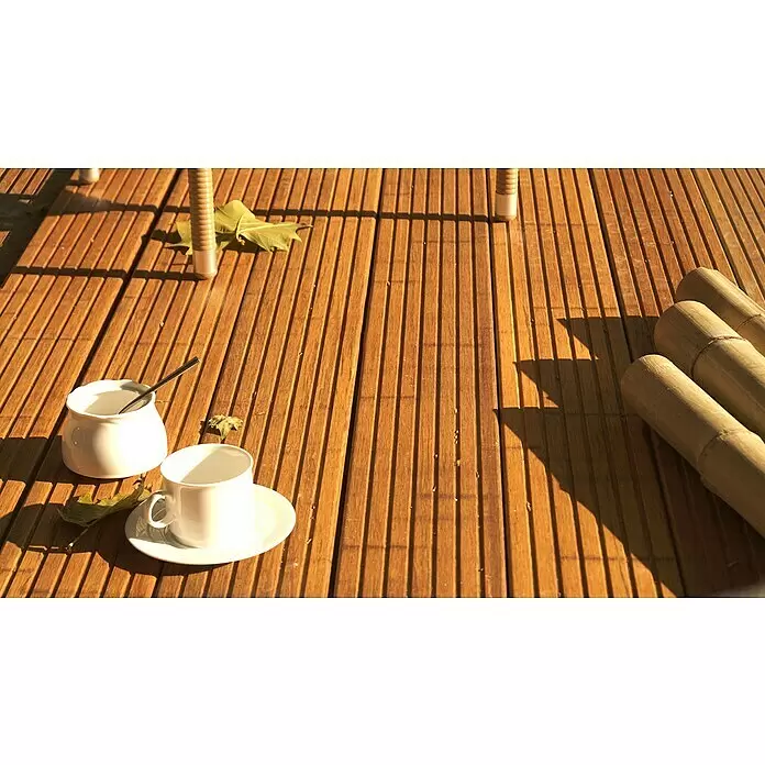 CoBaM Terrassendiele - Bambus, 220 x 14 x 2 cm, Braun - Weiße Keramiktasse und Zuckerdose auf sonniger Holzterrasse, mit Blättern und Bambusstangen.