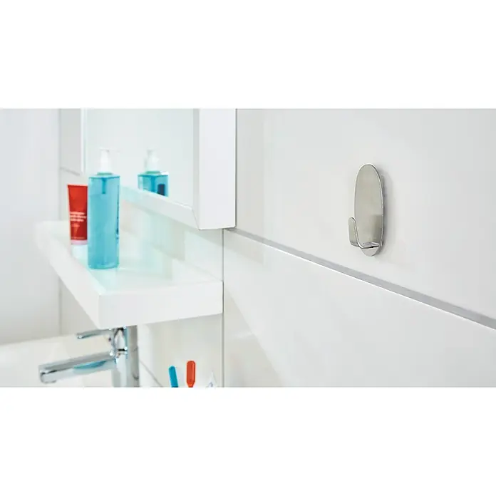 Tesa Powerstrips Selbstklebehaken - Oval, Größe: L, Metallic, 1 Stk. - Ein silberner, ovaler Handtuchhaken an einer weißen Badezimmerwand. Ideal für Handtücher und Bademäntel, der Haken bietet eine praktische Aufbewahrungslösung.