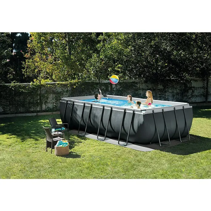Piscina Frame Ultra Quadra XTR - L x An x Al: 549 x 274 x 132 cm, Antracita, 17.203 l - Una piscina rectangular de Intex está instalada en el jardín, mientras que gente juega en el agua, una gran experiencia Intex al aire libre.