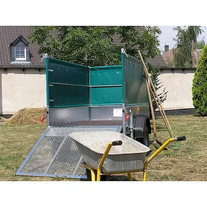 Stema Anhänger Green Keeper 750 mit Hochplane - Nutzlast: 588 kg, Einachser, Kasteninnenmaß: 201 x 108 x 26,5 cm, Ungebremst - Nutzanhänger mit grünen Planenaufsätzen und geöffneter Metallrampe, im Garten mit Schubkarre.