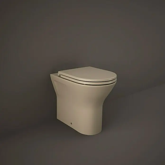 RAK Ceramics Feeling Stand-WC - Spülrandlos, Ohne Spezialglasur, Spülform: Tief, WC Abgang: Waagerecht, Cappuccino - Ein freistehendes, bodenstehendes WC in einem hellen Farbton vor einem neutralen, grauen Hintergrund. Das moderne Design fügt sich nahtlos in jedes Badezimmer ein.