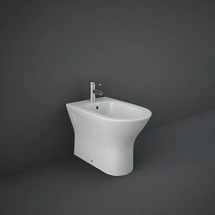 RAK Ceramics Feeling Stand-Bidet - 36 x 55 cm, Weiß, Keramik, Ohne Spezialglasur - Nahaufnahme eines weißen Stand-Bidets mit Armatur vor einem dunklen Hintergrund, das moderne Badezimmerdesign hervorhebt.